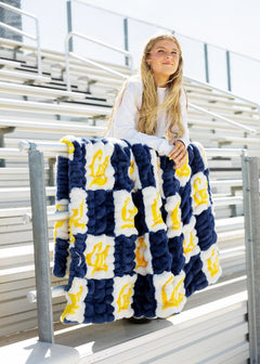Hugs Cal State Berkeley Bears Blanket draped over a person sitting in bleachers, showcasing school spirit and comfort.
