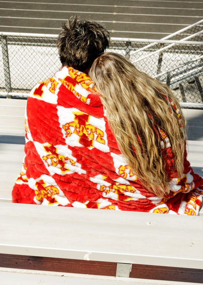 Couple snuggled in Iowa State Cyclones Blanket enjoying a day at the game with vibrant team colors.