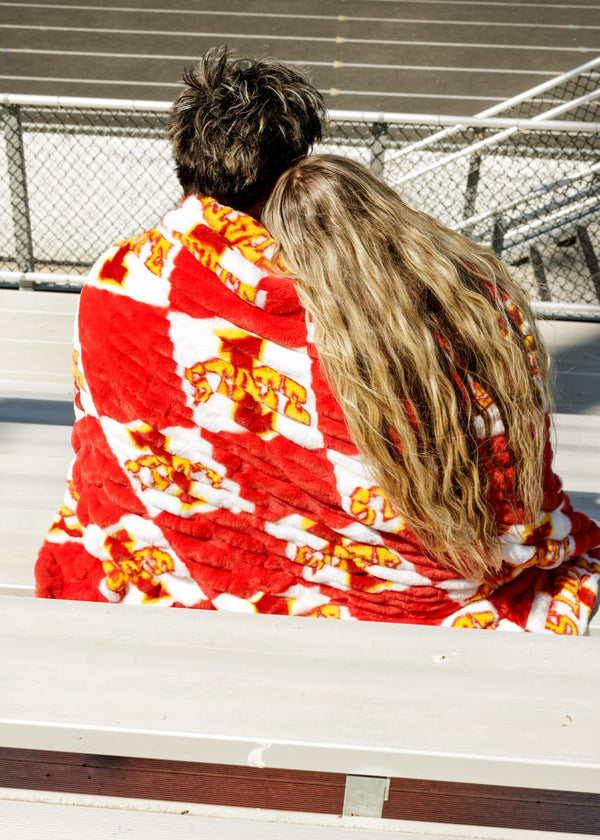 Couple snuggled in Iowa State Cyclones Blanket enjoying a day at the game with vibrant team colors.