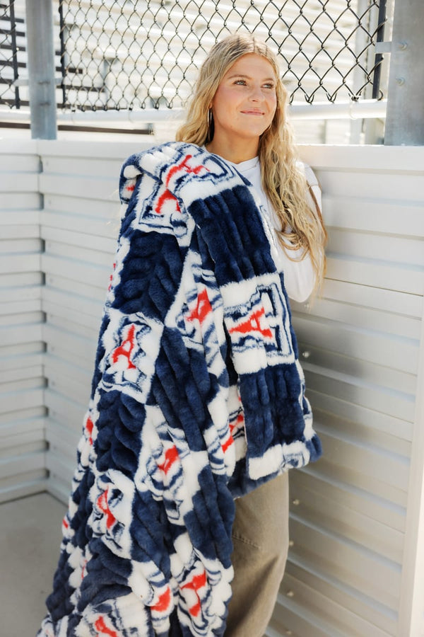 University of Arizona Wildcats Blanket displayed by a smiling person in a cozy setting.