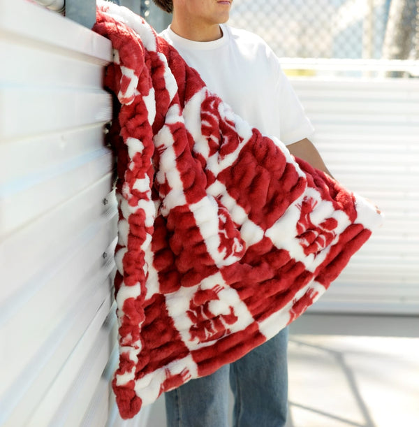 Washington State Cougars Blanket draped over a person showcasing its cozy crimson and checkered logo design.