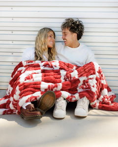 Cozy moments with the Washington State Cougars Blanket wrapped around a couple, showcasing school pride in crimson.