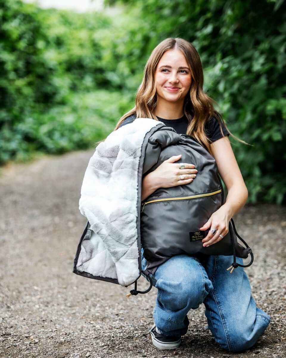  Charcoal Everywhere Blanket showcased by a woman outdoors, featuring portable design and water-resistant fabric.
