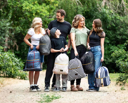 A family enjoying outdoor time with the Black Geo Everywhere Blanket, demonstrating its portability and style in nature.