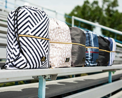 Assorted stylish backpacks with geometric patterns displayed on bleachers, perfect for school and outdoor activities.