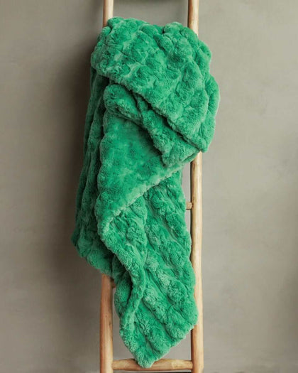 Ultra Sorbet Kelly Green weighted blanket draped over a wooden ladder, showcasing its plush texture and vibrant green color.
