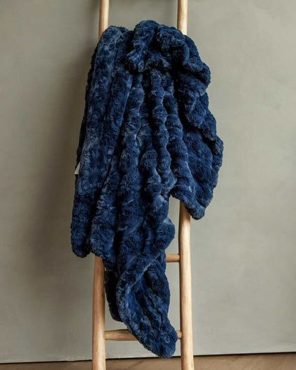 Ultra Sorbet Navy weighted blanket draped over a wooden ladder, showcasing its plush texture and deep navy color.
