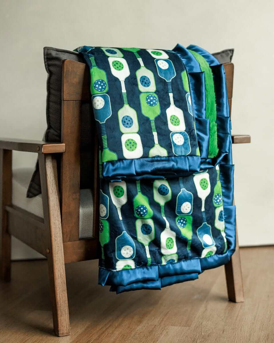 Pickleball Blanket showcasing a playful pickleball print draped over a wooden chair.