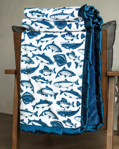 Fisher Blanket featuring playful blue fish patterns and navy blue plush minky backing, perfect for cozy nights.