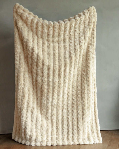 Ultra Sorbet Sand Blanket draped elegantly, showcasing its soft texture and neutral color, perfect for cozying up.