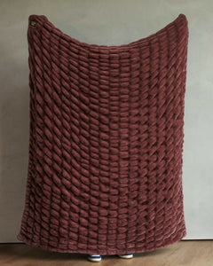 Warm brown textured Minky Hugs Rich Mahogany Blanket held up over a neutral background.