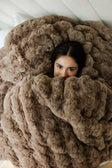 Cozy Ultra Sorbet Gingersnap Blanket in faux fur texture draped over a person for warmth and comfort.