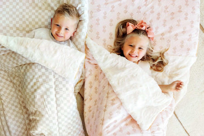 2 kids under beige checkered and pink floral Minky Couture Hampton Blooms Sleeping Bag.