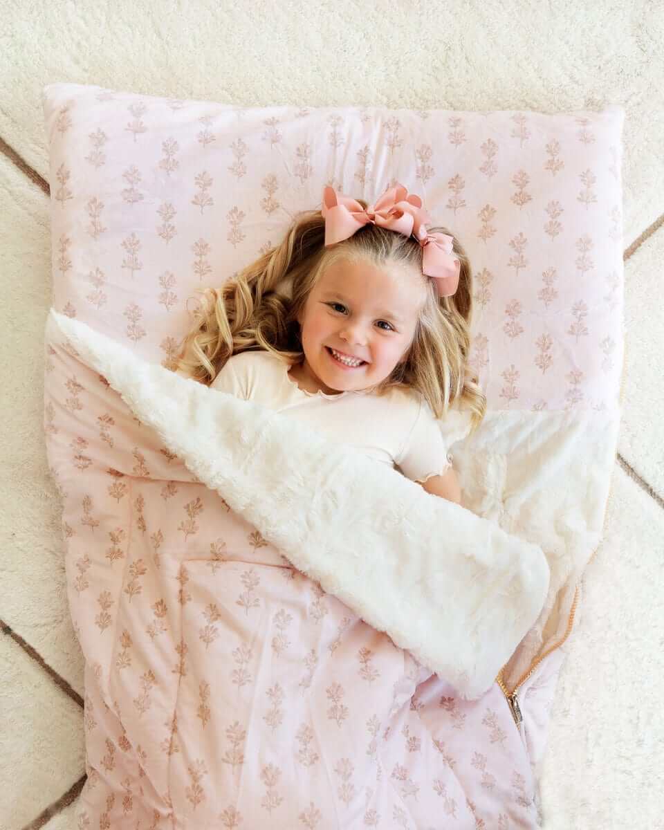Girl with pink bows under a pink floral Minky Couture Hampton Blooms Sleeping Bag-