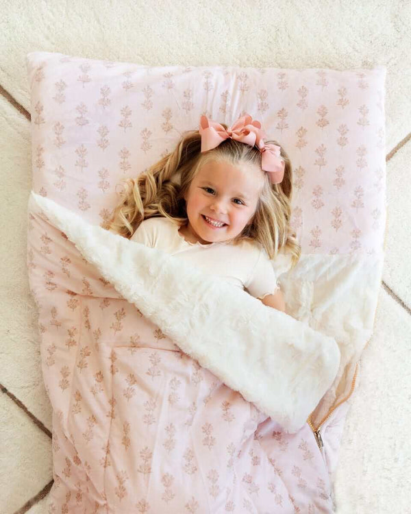Girl with pink bows under a pink floral Minky Couture Hampton Blooms Sleeping Bag-