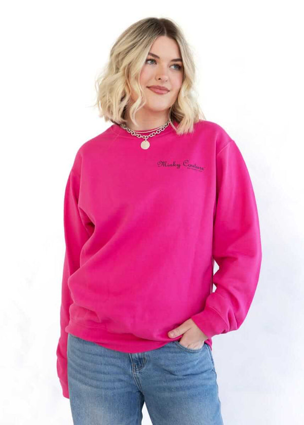 Model wearing a hot pink Minky Couture sweatshirt with logo on the front.