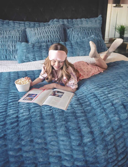 Girl reading on a bed with plush Minky Couture Hugs Denim Sham.
