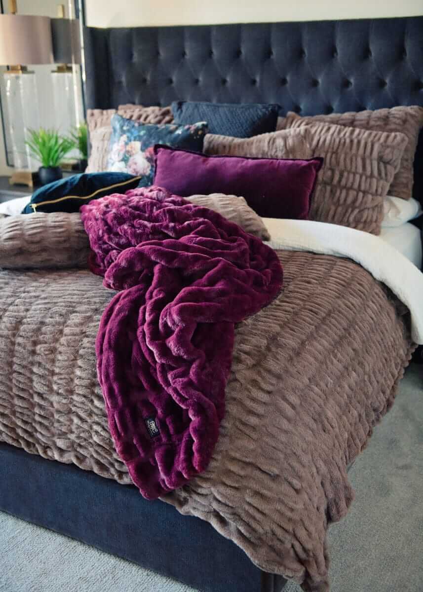 Plush Minky Couture blanket draped over a bed with Hugs Milk Chocolate bedding.