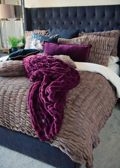 Plush Minky Couture blanket draped over a bed with Hugs Milk Chocolate bedding.