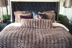 Bed with textured Minky Couture Hugs Milk Chocolate bedding and decorative pillows in a bedroom.