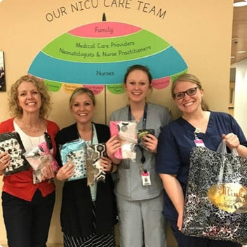NICU care team members smiling with gifts, showcasing care and support for families in a hospital setting.