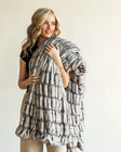 Woman draped in the Hugs Obsidian Blanket made of soft faux fur, showcasing its unique texture and warmth.