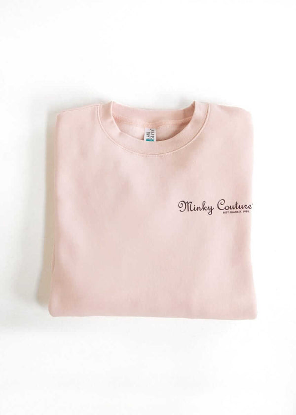 Folded light pink Minky Couture sweatshirt with embroidered logo.