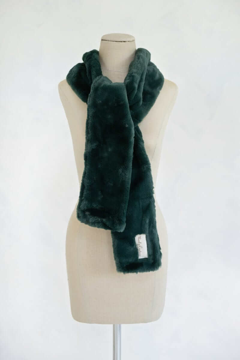 Lush Scarf displayed on a mannequin, showcasing its soft and cozy plush texture in a rich pine green color.