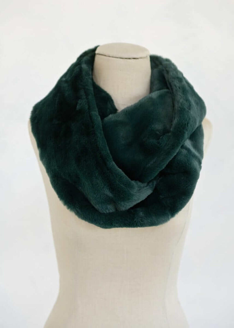 Lush Scarf displayed on a mannequin, showcasing its soft and cozy plush texture in a pine green color.