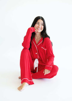 Model wearing Red Middle of the Night Pajamas, featuring long sleeves and accent trim, sitting pose.