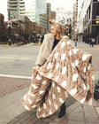 Woman holding a Hugs Polka Dot Milk Chocolate blanket on a city street.