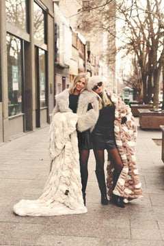 Two women wrapped up in two Minky Couture blankets standing on a city street.