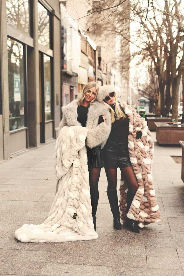 Two women wrapped up in two Minky Couture blankets standing on a city street.