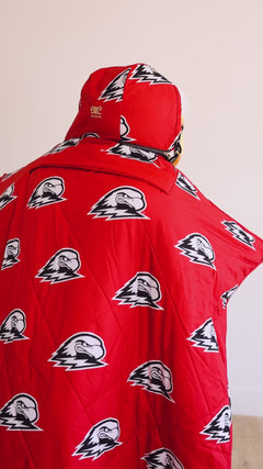 Southern Utah Thunderbirds mascot holding red and black Minky Couture collegiate blankets in a studio setting.