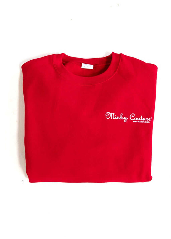 Folded red Minky Couture sweatshirt with embroidered logo.