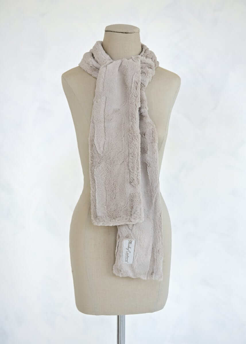 Sorbet Scarf in tranquil dove displayed on a mannequin, featuring a smooth texture in a light warm shade.