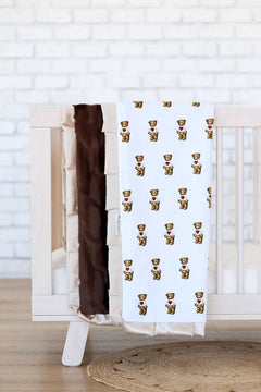 Teddy bear print Minky Couture Valentine Bear baby blanket draped over a crib.