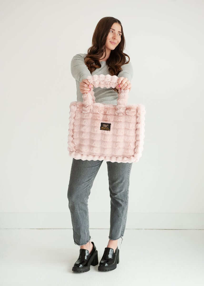 Woman modeling the Annie Bag Ripple Blush, showcasing its luxurious style and unique texture.