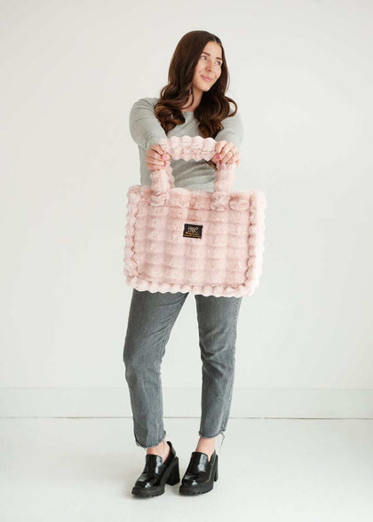 Woman modeling the Annie Bag Ripple Blush, showcasing its luxurious style and unique texture.