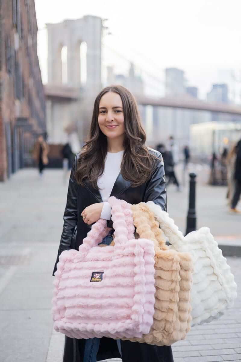 Woman holding three Annie Bag Ripple Blush styles in different colors, showcasing luxury and versatility.