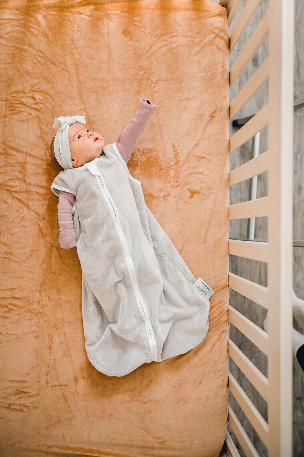 Infant in cozy Minky Crib Sheet, enjoying comfort and warmth during sleep on a soft, plush bed.