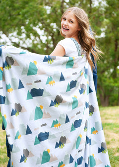 Girl twirling with a mountain top themed blanket by Minky Couture.