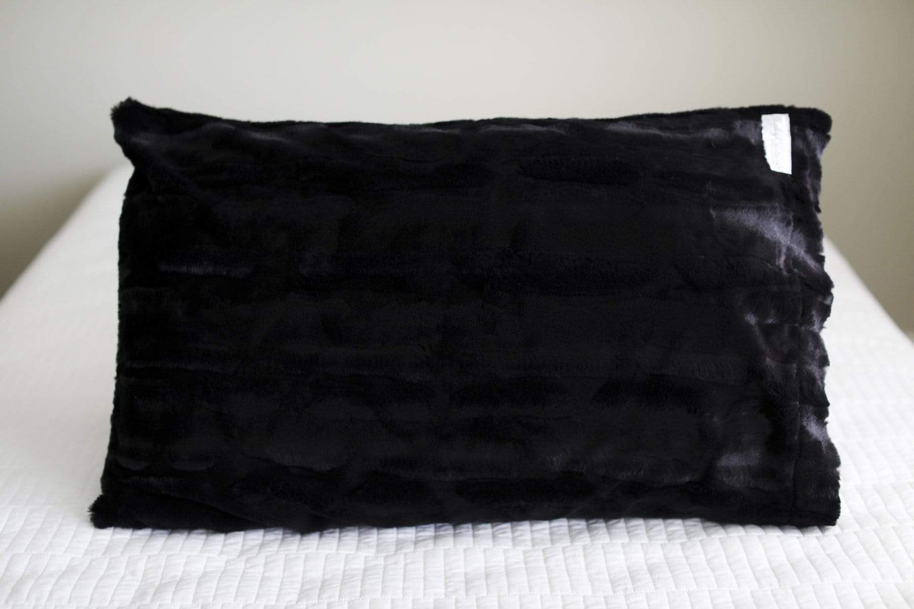 Black | Black plush pillowcase by Minky Couture sitting on a bed. 