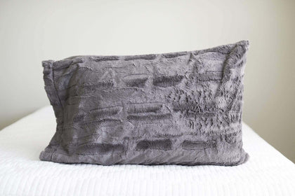 Charcoal | Charcoal gray plush Minky Couture pillowcase sitting on a bed. 
