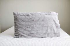 Silver | Light gray plush Minky Couture pillowcase sitting on a bed. 