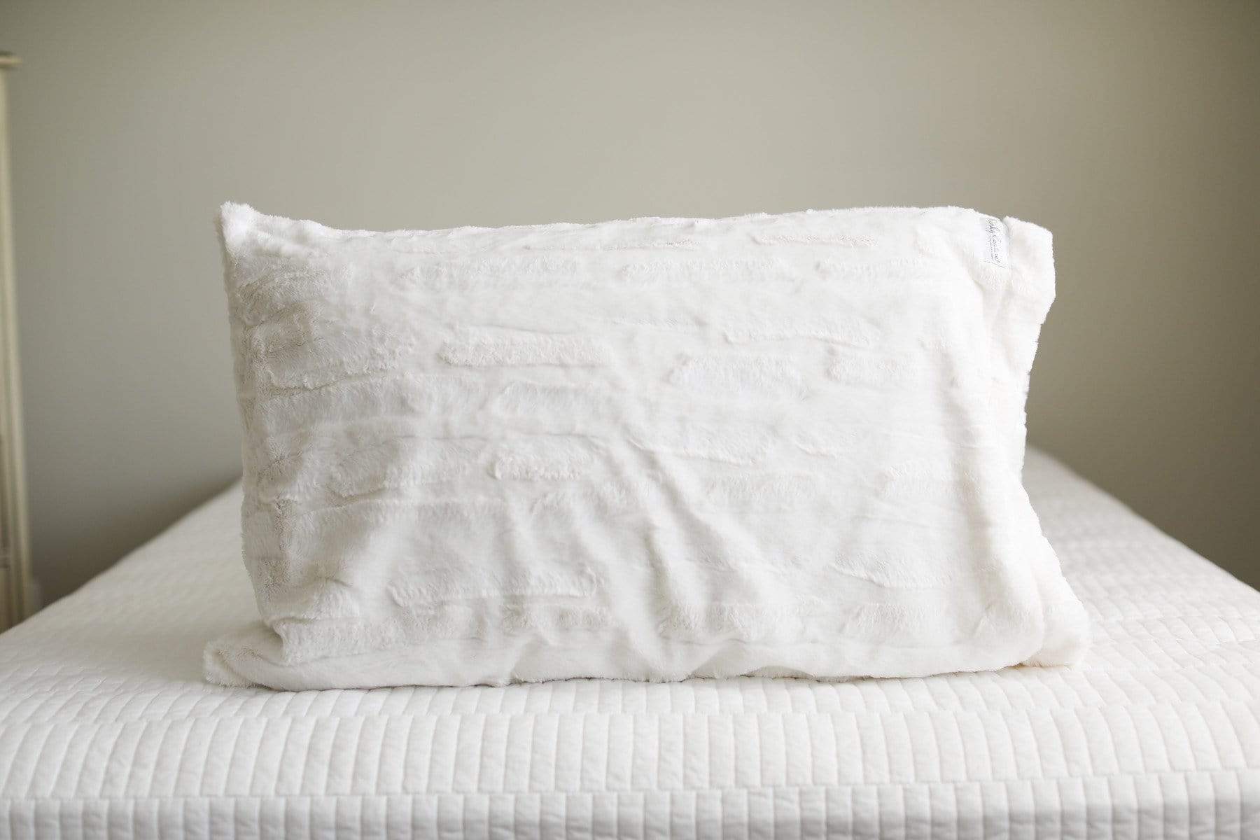 Vanilla | Creamy white Minky Couture plush pillowcase sitting on a bed. 