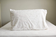 Vanilla | Creamy white Minky Couture plush pillowcase sitting on a bed. 