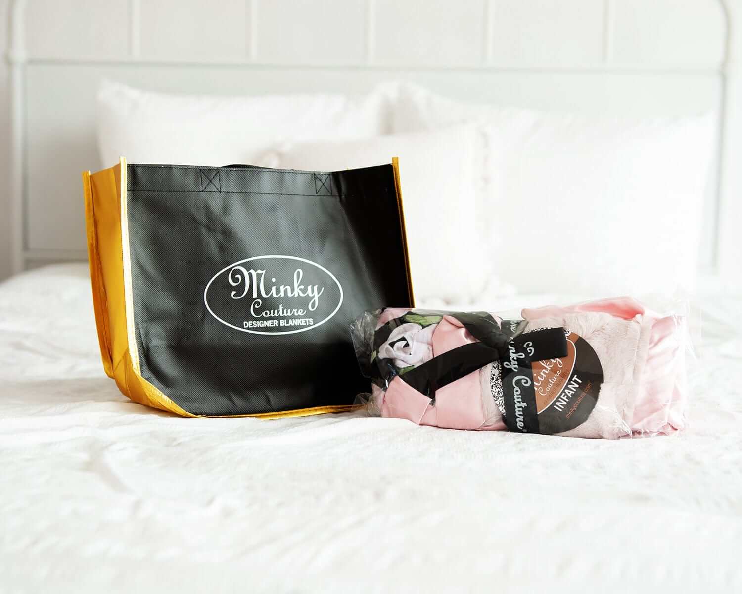 Reusable Shopping Bag by Minky Couture with a bundle of designer blankets displayed on a bed.