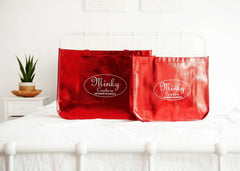 Shopping Bag: Minky Couture's reusable red shopping bags displayed on a bed, perfect for gifts and groceries.