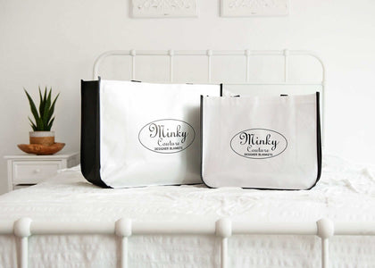 Two Minky Couture reusable Shopping Bags displayed on a bed, showcasing their design and versatility for various uses.